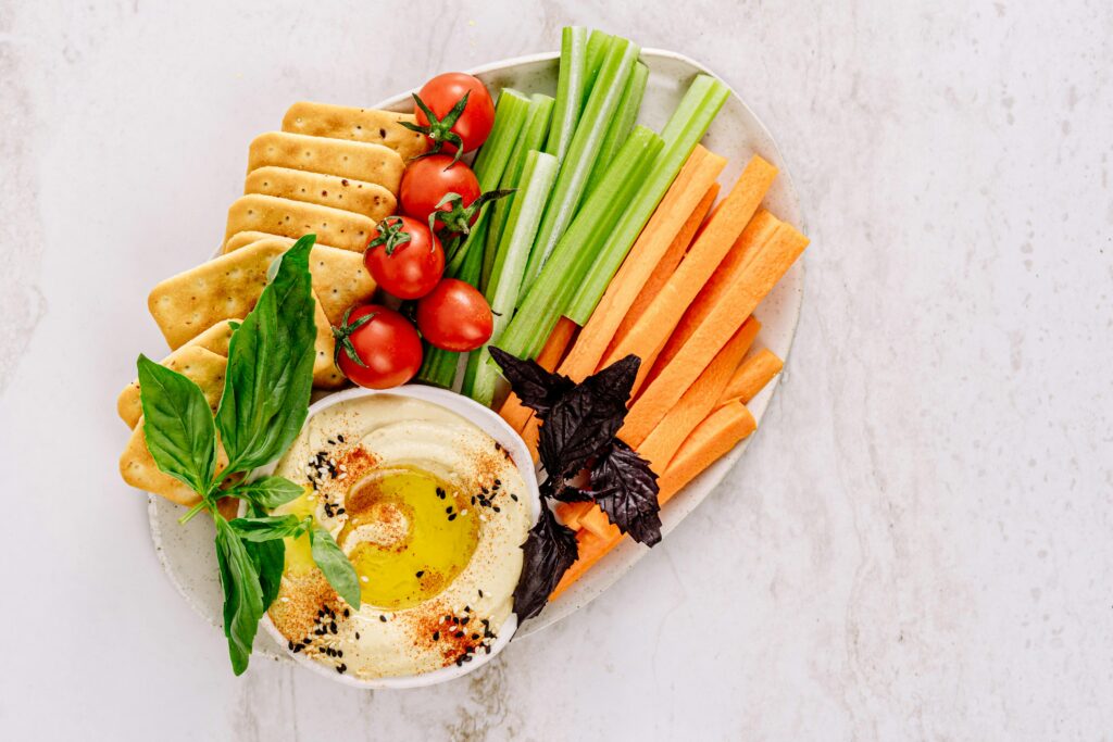 Top view of a delicious vegetable platter with hummus, ideal for healthy snacking.